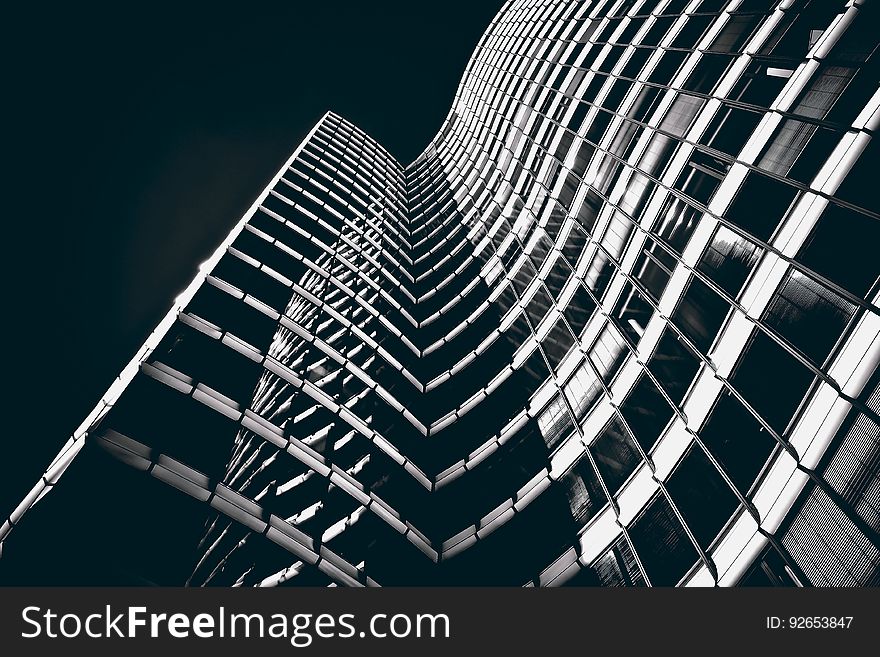 A high rise building with a curved facade in black and white.