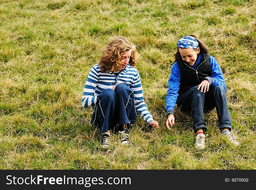 Portrait of friends sitting on grass and chatting. Portrait of friends sitting on grass and chatting