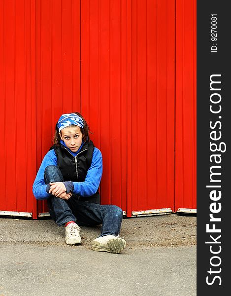 Portrait of modern child leaning against red wall. Portrait of modern child leaning against red wall