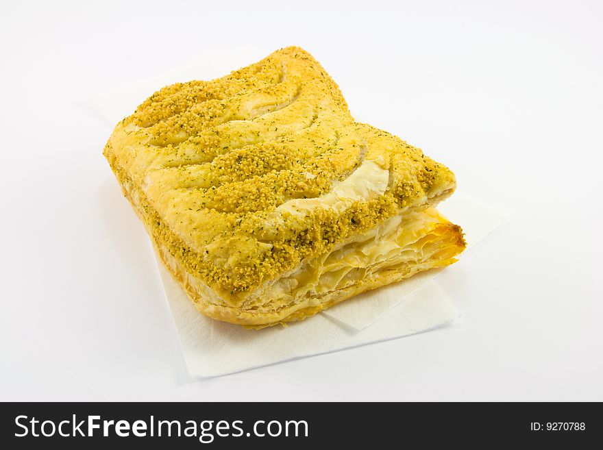 Single whole pasty on a napkin with a white background