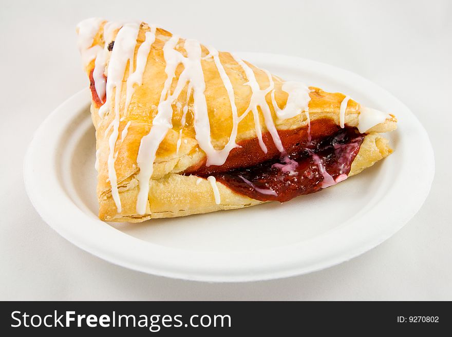 Cherry danish pastry on a plate on a white background