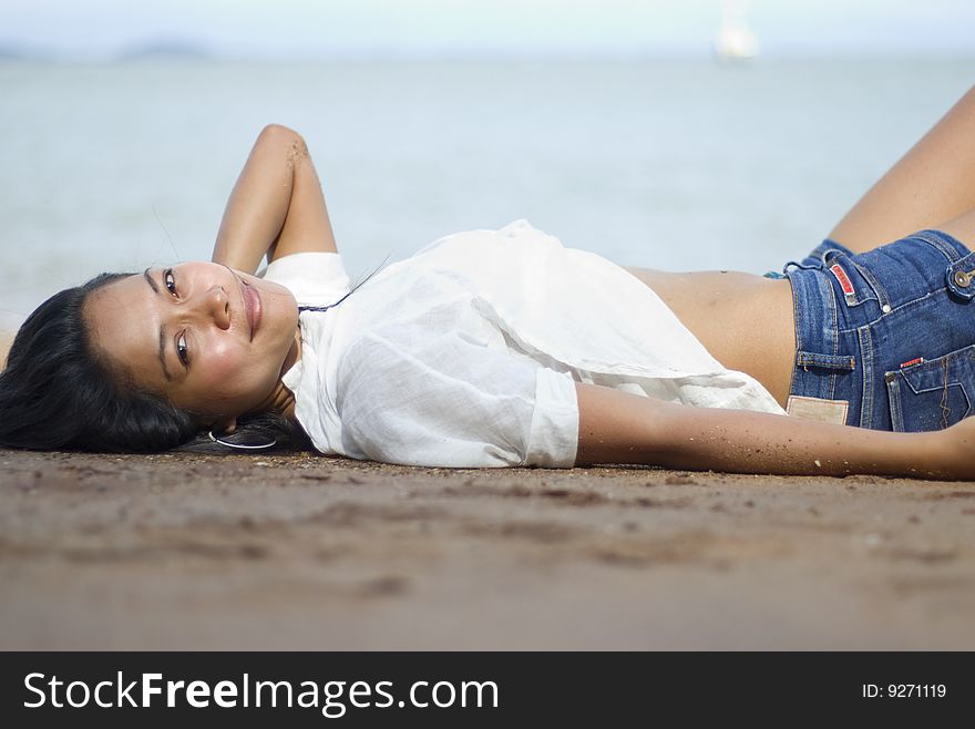 Pretty girl in casual clothes laying on the beach. Pretty girl in casual clothes laying on the beach.