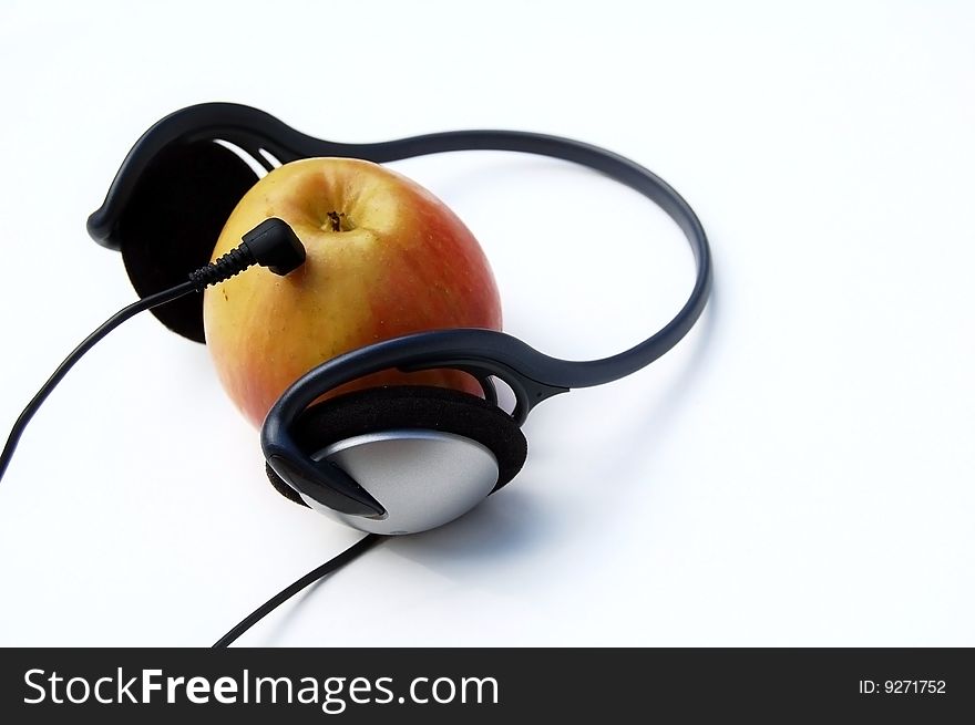Apple and headphones on white background - mp3 player concept. Apple and headphones on white background - mp3 player concept