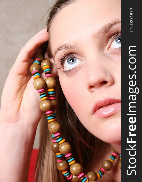 Beautiful female model with blue eyes and a string beads