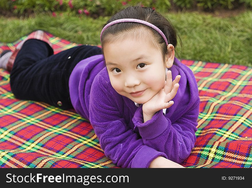 A girl lying on a picnic mat rest. A girl lying on a picnic mat rest