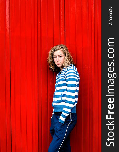 Portrait of teenage girl against red wall