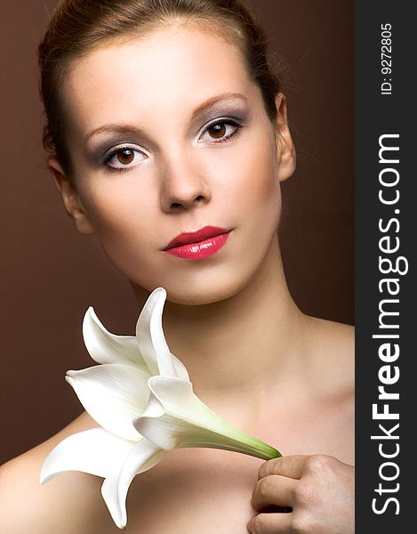 Beauty portrait of a young woman with a lily flower. Beauty portrait of a young woman with a lily flower
