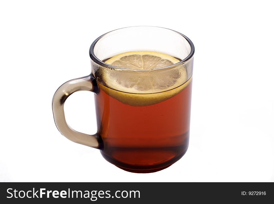 The mug of tea with a lemon, is photographed on a white background
