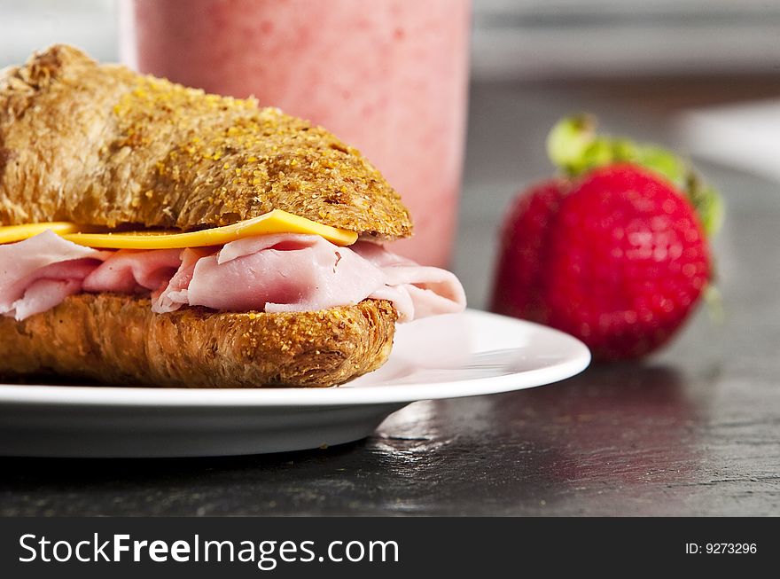 Continental breakfast with croissant and strawberry smoothie
