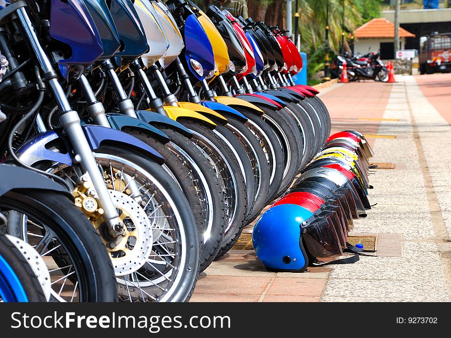 Row of Motorcycles Parked on Street and Row of Helmet. Row of Motorcycles Parked on Street and Row of Helmet.