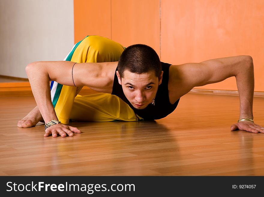 Young muscular dancer posing in dance hall. Young muscular dancer posing in dance hall