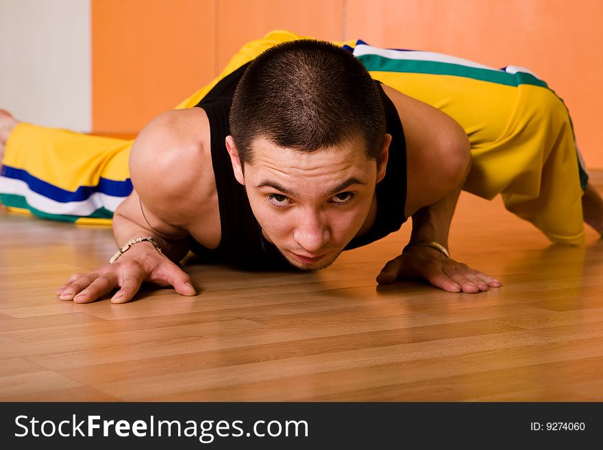 Young muscular dancer posing in dance hall. Young muscular dancer posing in dance hall