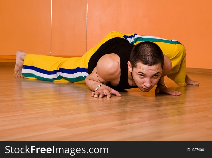 Young muscular dancer posing in dance hall. Young muscular dancer posing in dance hall