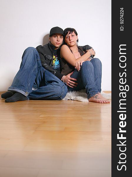 Young stylish couple sitting on the floor of their new home!. Young stylish couple sitting on the floor of their new home!