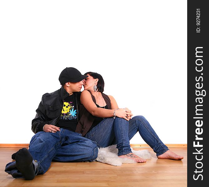 Young stylish couple kissing on the floor of their new home!. Young stylish couple kissing on the floor of their new home!