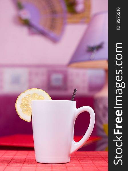 White cup with black tea and piece of lemon. White cup with black tea and piece of lemon