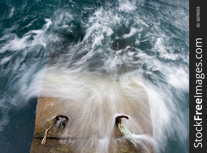 Blue sea with wave and brown stone pier. Blue sea with wave and brown stone pier