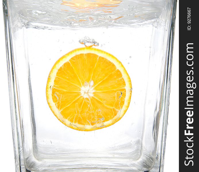 Fresh orange slice splashing into transparent water. Fresh orange slice splashing into transparent water