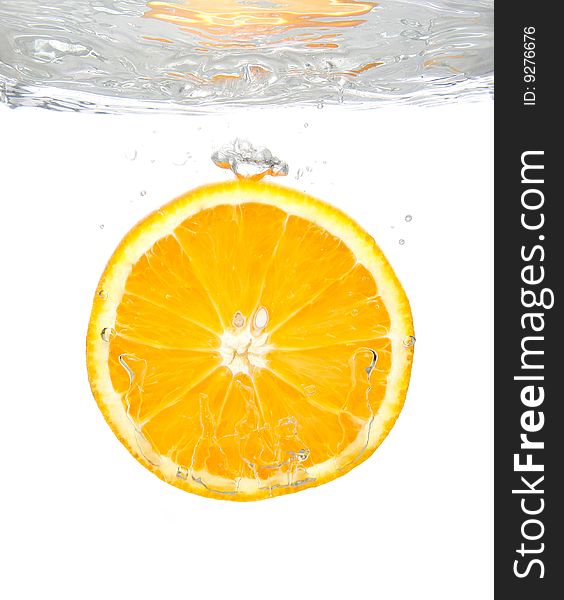 Fresh orange slice splashing into transparent water. Fresh orange slice splashing into transparent water