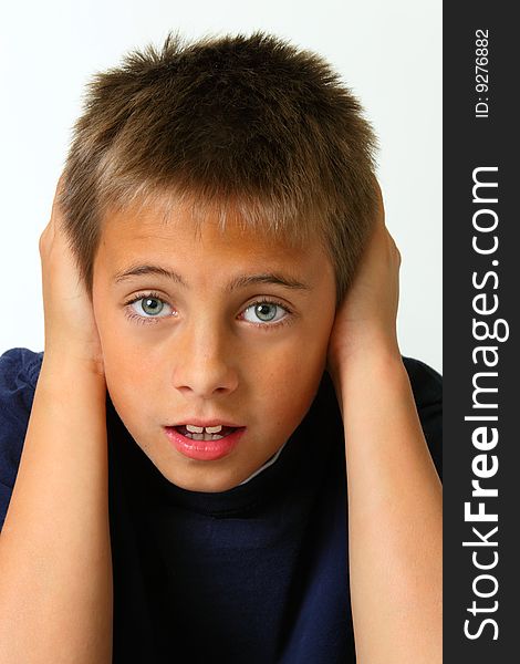 Boy covering ears against white background. Boy covering ears against white background