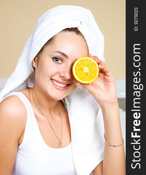 Pretty young woman sitting on the bed at home and eating oranges. Pretty young woman sitting on the bed at home and eating oranges