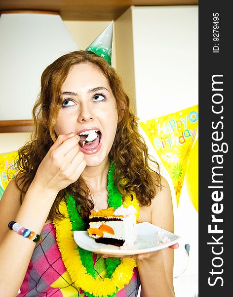 Portrait of a happy girl celebrating birthday and eating a cake