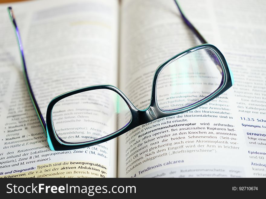 Closeup of reading glasses on a book.