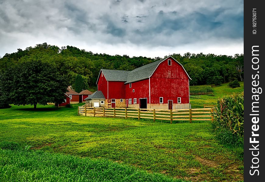 A typical red barn in the middle of green fields.