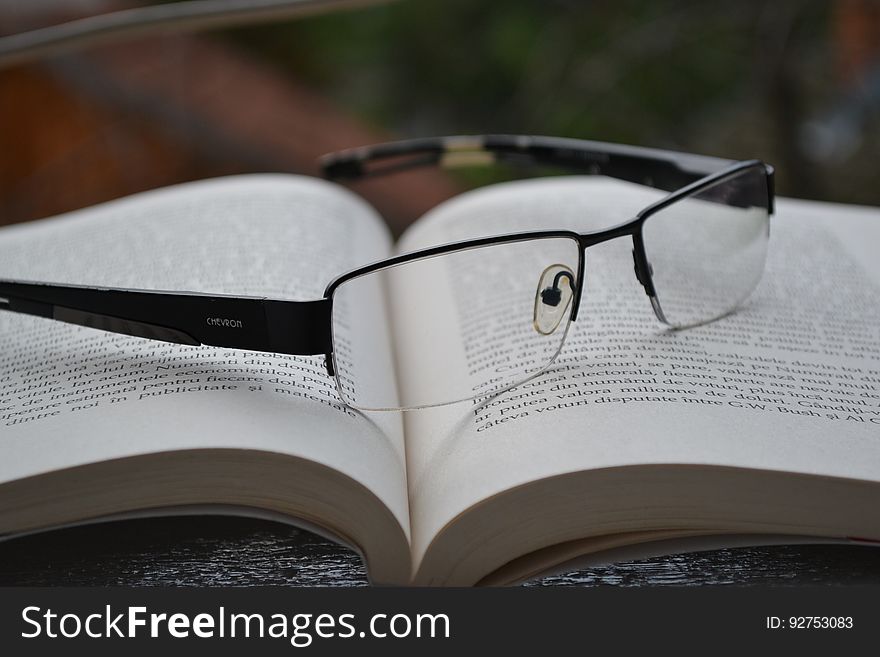 A pair of eyeglasses on an open book. A pair of eyeglasses on an open book.