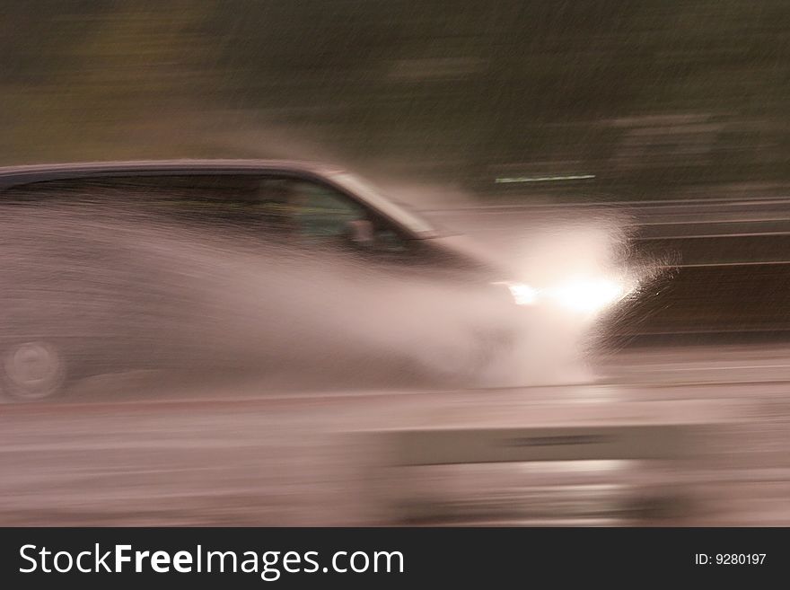 Car on the street with splashing water