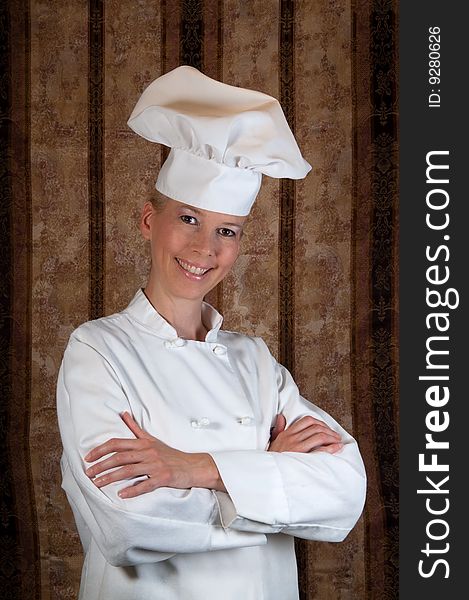 Assertive posed portrait of an attractive female Executive Chef proudly standing against an elegant background. Assertive posed portrait of an attractive female Executive Chef proudly standing against an elegant background.