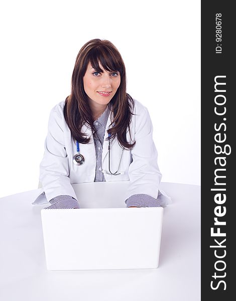 Female doctor on computer at desk isolated on white