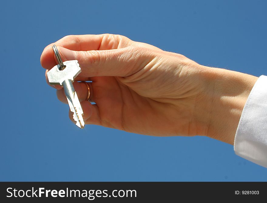 Key in a palm over blue background