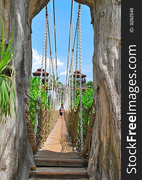 Wooden suspension bridge leading to paradise island, with hotels and resorts in the background. Wooden suspension bridge leading to paradise island, with hotels and resorts in the background