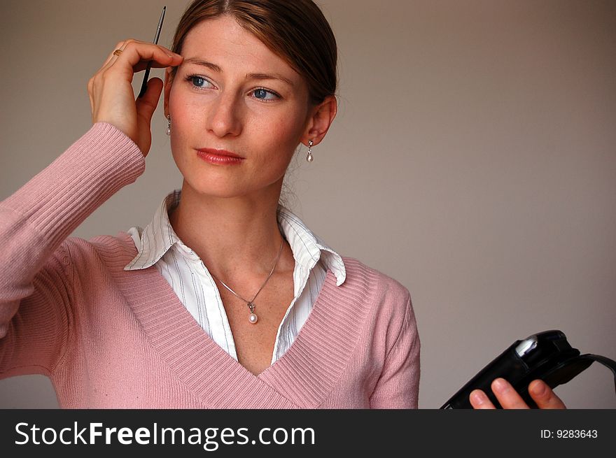 Attractive thoughtful woman holding a pda. Attractive thoughtful woman holding a pda