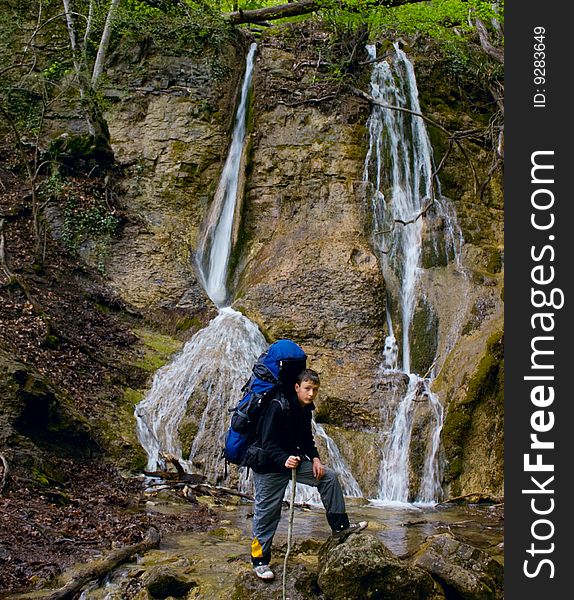 Mountain waterfall and boy is hiker