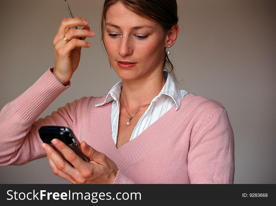 Attractive thoughtful woman holding a pda. Attractive thoughtful woman holding a pda