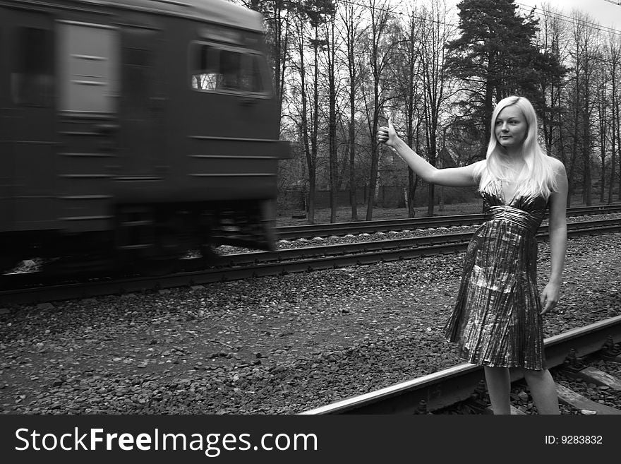 Girl hitchhiking a train on the railroad