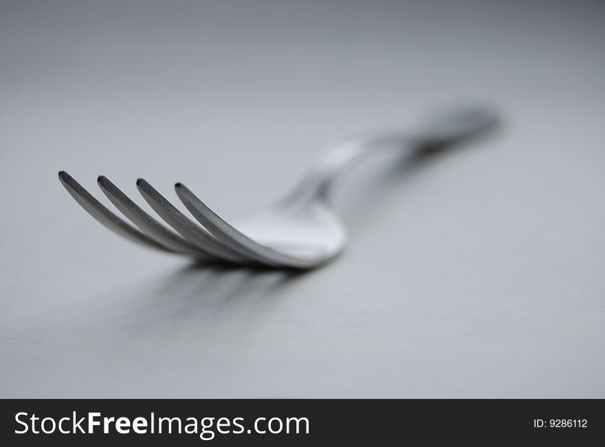 Steel fork lying on the gray surface