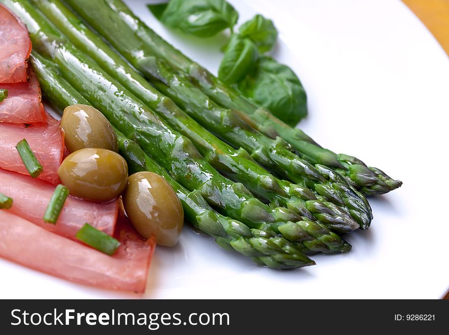 Green asparagus with sausages and olives.