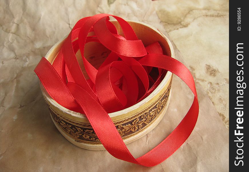 Red ribbon in small box. Still life