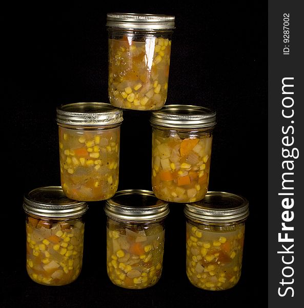 Canned vegetable soup on black background placed in a pyramid