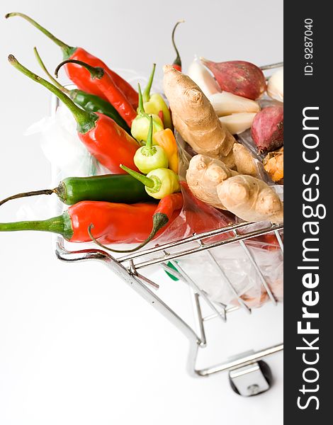 Variety of seasoning ingredients on a trolley isolated on white - vegetables shopping. Variety of seasoning ingredients on a trolley isolated on white - vegetables shopping