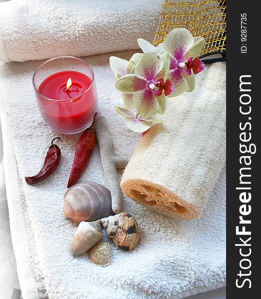 Towels, candle, orchid, and bath sponge in a spa. Towels, candle, orchid, and bath sponge in a spa