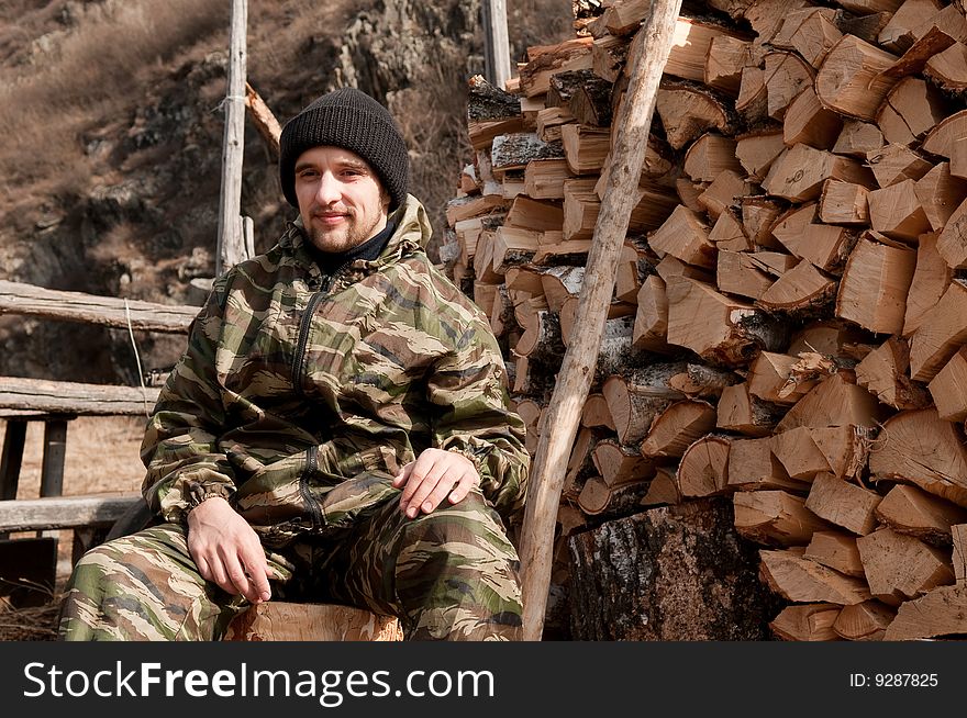 A Man Near Pile Of Firewood