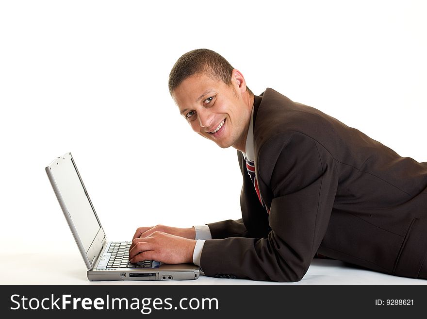 Businessman lying on the floor using a notebook. Businessman lying on the floor using a notebook