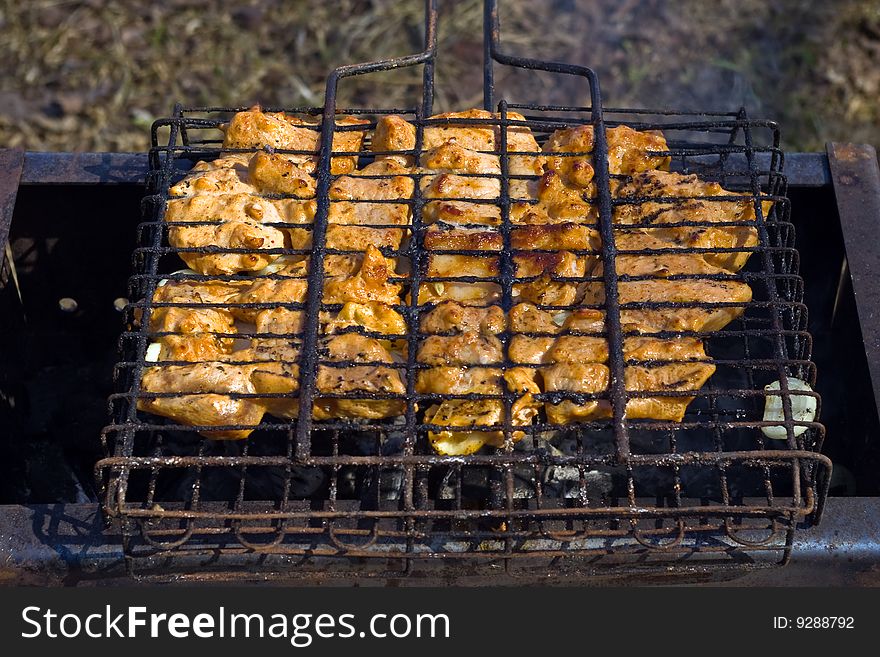 Sizzling hot meat, fried on a lattice above coal