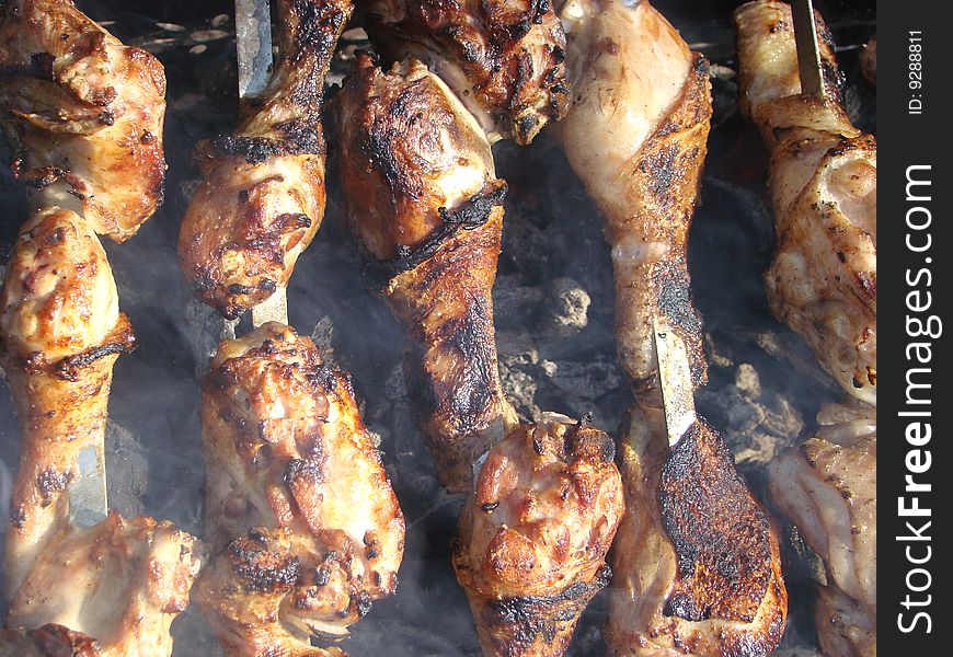 Pieces of a chicken shish kebab are fried over coals