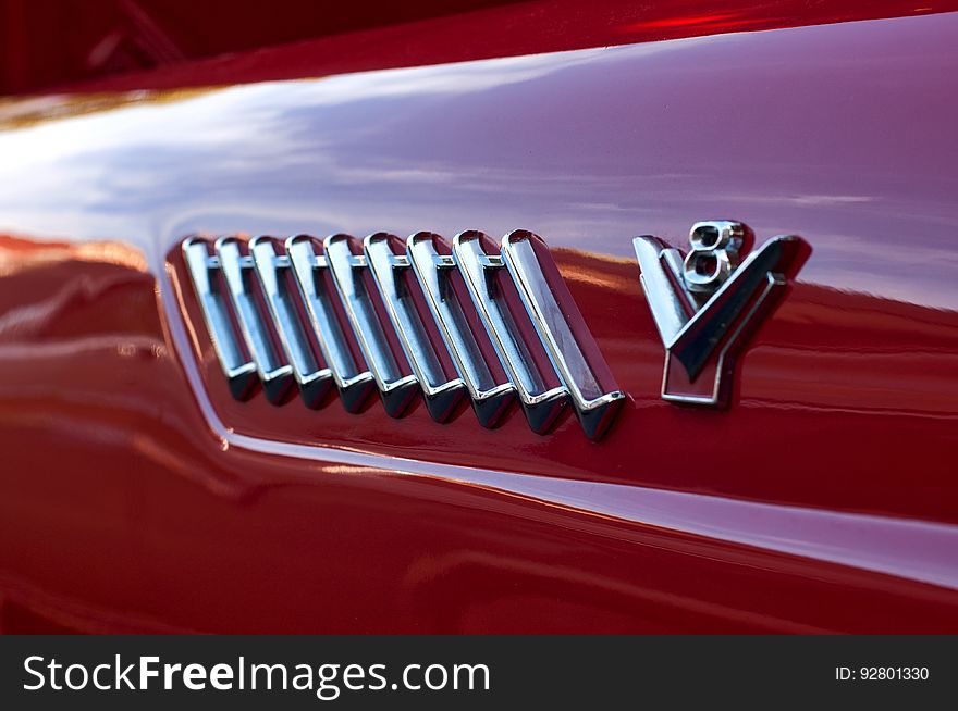 A close up of a grill and the emblem on a V8 Ford truck. A close up of a grill and the emblem on a V8 Ford truck.