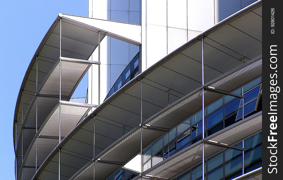 A modern building with curved scaffolding around the exterior.